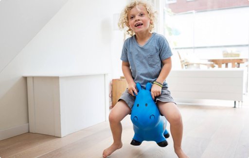 Enfant sautant avec un jouet bleu